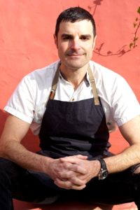 Chef Aran Goldstein sitting wearing an apron